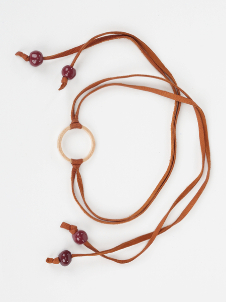 Tan leather Bonjou Wrap Bracelet with wooden ring center, and dark red ceramic beads. Top view arranged in a loop.