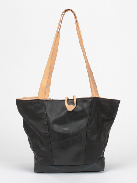 Black leather Caribbean Tire Tote with inner tube front panel and bottom, natural leather straps, and wooden button closure by deux mains. Front view.