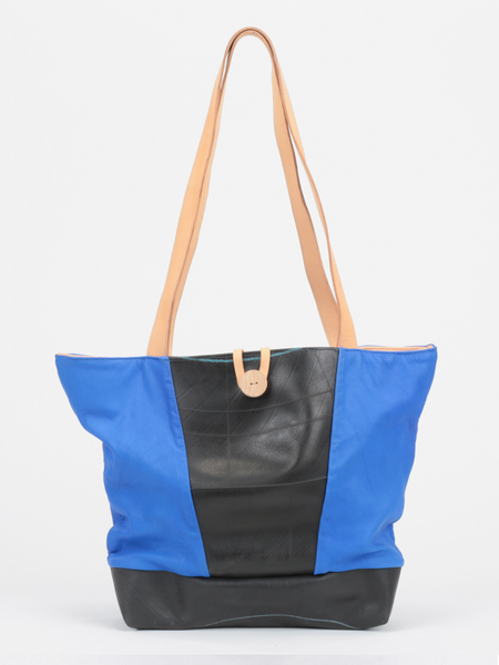 Royal Blue leather Caribbean Tire Tote with inner tube front panel and bottom, natural leather straps, and wooden button closure by deux mains. Front view.