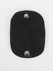 Black and natural leather  Bèl Mizik Earbud Holder with snap closure. Front view showing the open black leather exterior. 