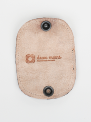 Cognac and natural leather  Bèl Mizik Earbud Holder with snap closure. Interior view showing natural leather and deux mains logo.