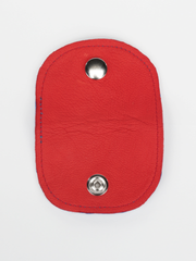 Denim and inner tube Bèl Mizik Earbud Holder with snap closure. Exterior view showing the open red leather. 
