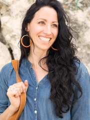 Tan leather Hispaniola Hoop Earrings with individually crafted wooden circle centerpiece. Portrait of female model wearing earrings. 